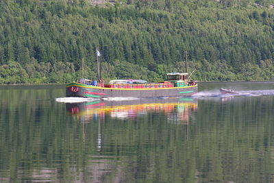 Boats in river against trees