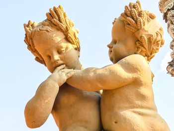 Low angle view of angel statue against sky