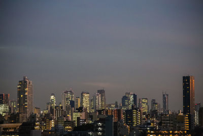 Illuminated cityscape against sky