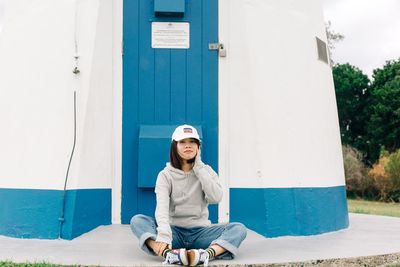 Portrait of young man sitting on wall