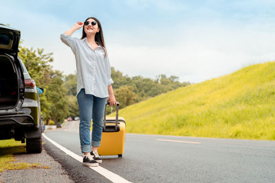 Woman standing on road against sky