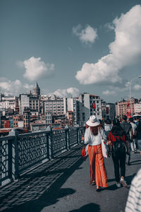 Rear view of people walking on street in city