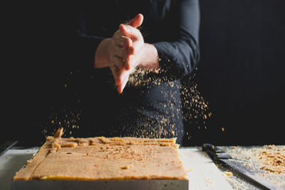 Close-up of chef's hands preparing sponge cake