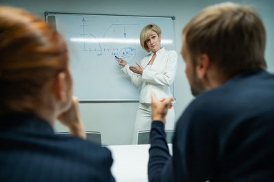 Caucasian woman blonde leads a presentation for colleagues