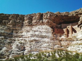 Low angle view of rocks against blue sky