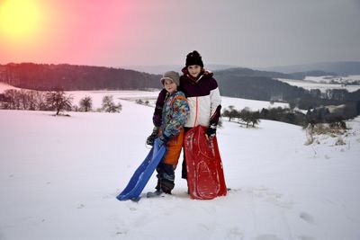 Portrait of woman standing on snow covered mountain