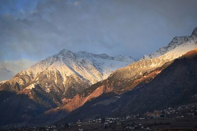 Scenic view of snowcapped mountains against cloudy sky