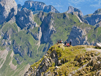 Rear view of group of hikers enjoying the scenic view by alpine landscape