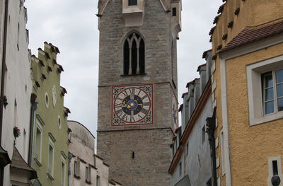 Low angle view of clock tower amidst buildings