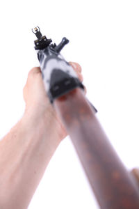 Close-up of hand holding camera over white background