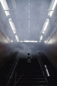 Rear view of woman standing on subway station