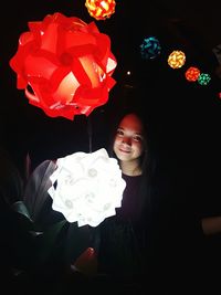 Smiling young woman against black background