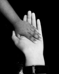 Cropped image of hand against black background