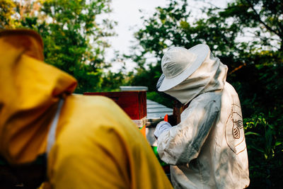 Beekeepers standing by beehive