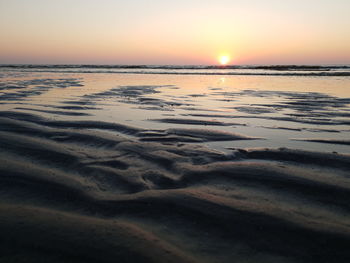 Scenic view of beach against sky during sunset