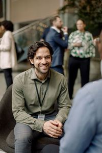 Smiling male entrepreneur discussing with delegate during seminar at convention center