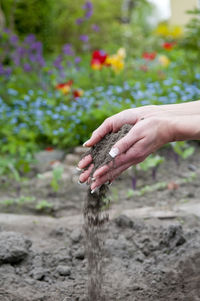 Cropped hands of woman spilling dirt