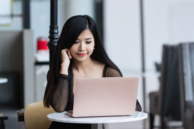 Young woman using mobile phone at cafe