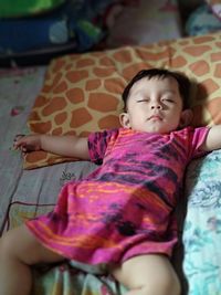 High angle view of cute baby girl sleeping on bed at home