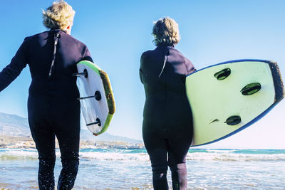 Rear view of woman standing in sea