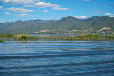 Scenic view of sea and mountains against sky