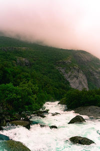 Scenic view of waterfall against sky