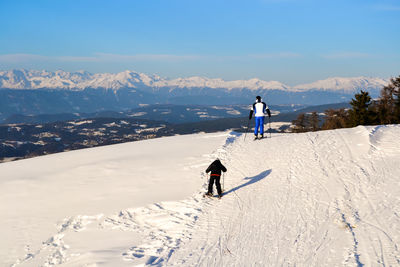 People on snowcapped mountain against sky