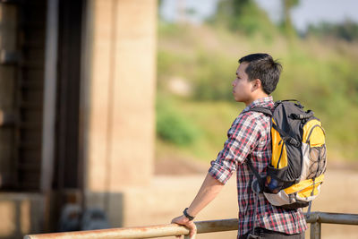 Side view of young man standing outdoors