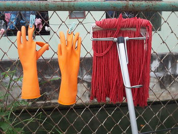 Close-up of clothes hanging on chainlink fence