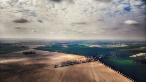 Aerial view of landscape against cloudy sky during sunset