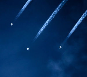 Close-up of airplane flying in blue sky