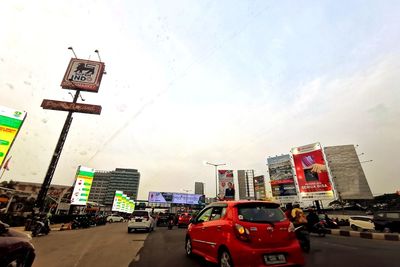 Traffic on road in city against sky