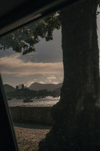 Scenic view of river by city against sky at sunset