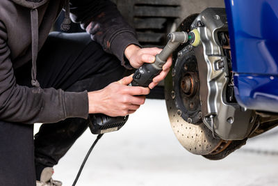 Midsection of man repairing car