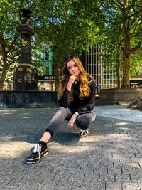 Full length portrait of woman sitting outdoors