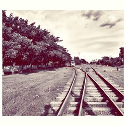 Railroad track against cloudy sky