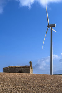 Low angle view of windmill against sky