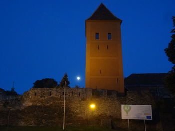 Low angle view of illuminated tower against clear sky