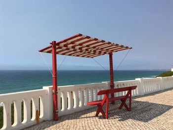 Deck chairs on beach against clear sky