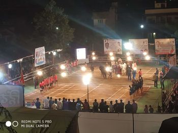 People on illuminated street at night