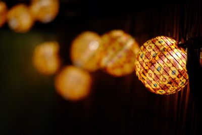 Close-up of illuminated lighting equipment hanging at night