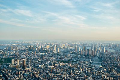 High angle view of buildings in city against cloudy sky