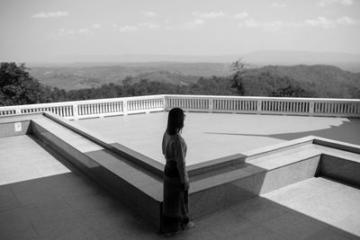 Rear view of woman looking at swimming pool against sky