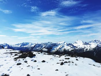 Scenic view of snowcapped mountains against blue sky