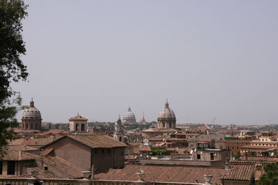 Buildings in city against clear sky