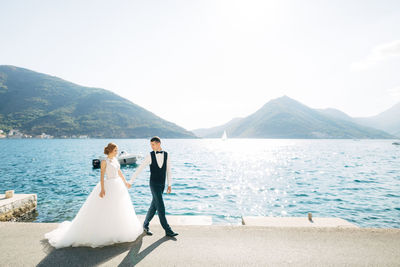 Couple walking on road near sea