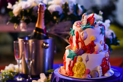 Ocean themed birthday cake with champagne and white flowers in the background