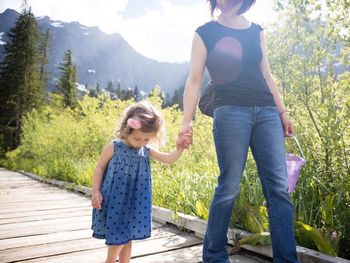 Full length of mother and daughter walking in park