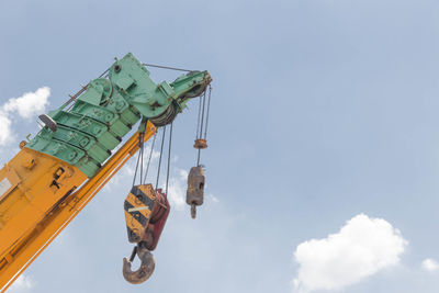 Low angle view of crane against sky
