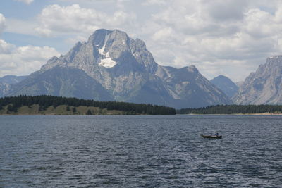 Scenic view of lake by mountains against sky